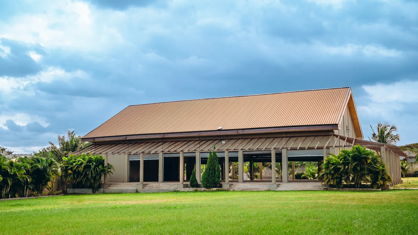 The auditorium seen across the lawn, open along its length under a pitched roof