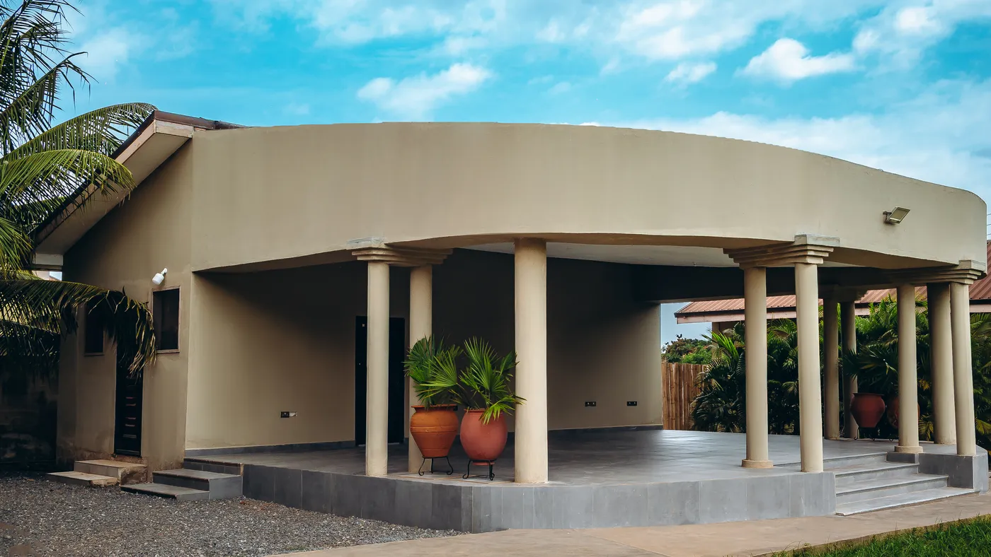 The terrace, a curved roof carried on columns above a tiled floor